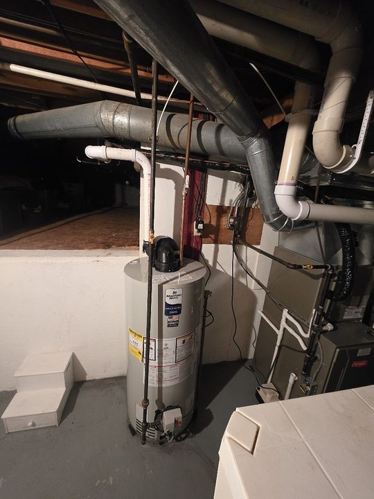 Gas water heater and furnace with their vent piping in a basement on an A.W. Crooks job