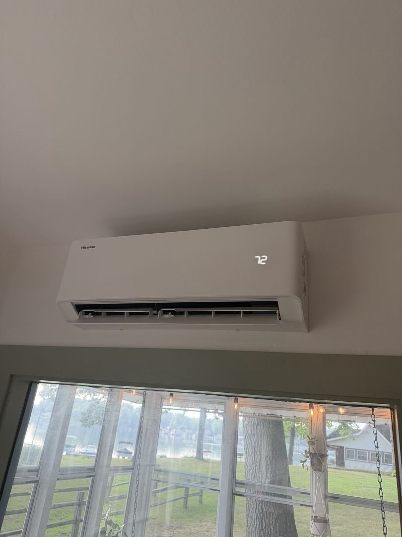 Mini split indoor head mounted on the wall above a window